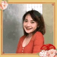 a woman in a red shirt is surrounded by flowers and a fan
