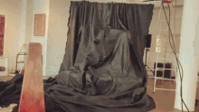 a large piece of black cloth is covering a statue
