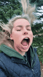 a woman with her eyes closed and her tongue out