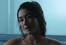 a woman without a shirt is taking a bath in a tub .