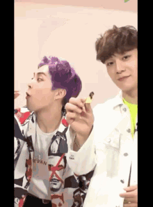 a man with purple hair and a shirt that says efan