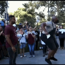 a man wearing a shirt that says ' i love you ' on it is dancing in front of a crowd