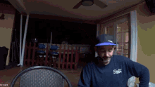 a man wearing a blue shirt with the word salt on it sits in a chair