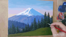 a person is painting a mountain with a brush and the words made in animatica on the bottom