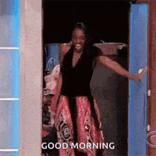 a woman in a dress is standing in a doorway with her arms outstretched and says `` good morning '' .