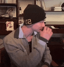a man wearing a black beanie with the number 02 on the side