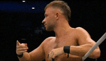 a man without a shirt is standing in a boxing ring with a ring around his wrist