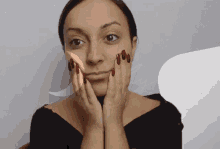 a woman with red nails is making a funny face