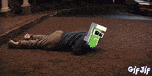 a gif of a person laying on the ground with a car in the background that says gif jif