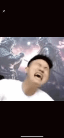 a man in a white shirt is making a funny face in front of a wall .