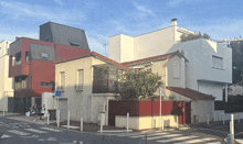 a white building with a red fence and a blue sign that says ' a ' on it