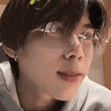 a close up of a person wearing glasses and a gray shirt