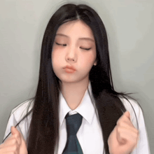 a girl wearing a white shirt and tie is making a funny face