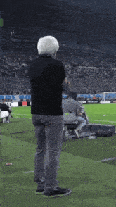 a man in a black shirt is standing on a field