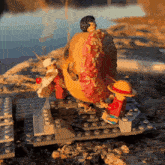 two lego figures are standing next to a donut on a rock