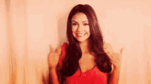 a woman is smiling and giving a thumbs up .