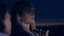 a woman is sitting in a car with a man looking at her