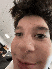 a close up of a person 's face in front of a sign that says fresh groceries