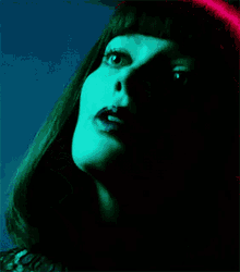 a close up of a woman 's face with a green light behind her