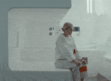 a woman sits on a couch in a room with the word keg on the bottom left