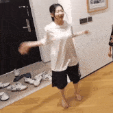 a woman in a white t-shirt and black shorts dancing