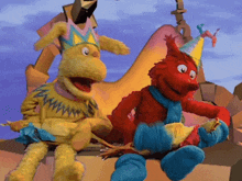 two stuffed animals wearing party hats and scarves are sitting on a rock