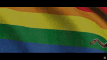 a rainbow flag with a person 's hands reaching out towards it