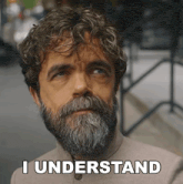 a man with a beard says " i understand " in front of his face