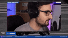 a man wearing headphones and glasses is on a racing cafe screen