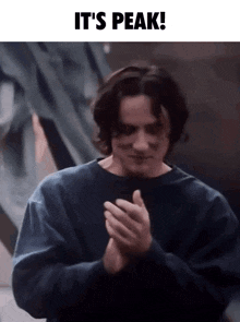 a man clapping his hands with the words it 's peak written above him