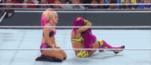 two women are wrestling in a wrestling ring and one is kneeling down .