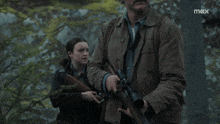a man and a girl holding guns in a scene from max