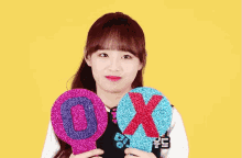 a girl with red hair is holding a sign that says x