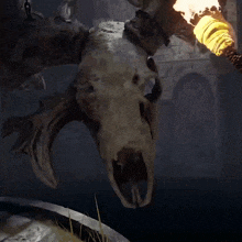 a skull with horns is hanging from a chain
