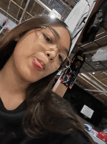a girl wearing glasses takes a selfie in front of a sign that says no smoking