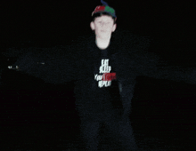 a young boy wearing a hat that says ' a ' on it is standing in the dark