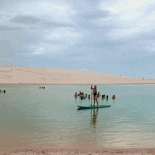 a woman in a black swimsuit is standing on a paddle board