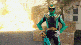 a green and black superhero is holding a sword in front of a building
