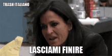 a woman is sitting at a table with a piece of paper in her hand and a caption that says trash italiano lasciami finire