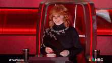 a woman sitting in a chair with a nbc logo on the bottom right
