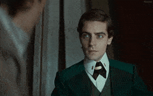 a man in a green suit is looking at himself in a mirror with the word kepler in the corner