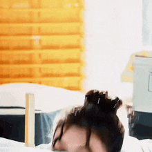 a person is laying on a bed with their head on a pillow and their hair is blowing in the wind .