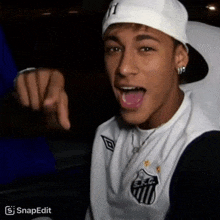 a young man wearing a hat with the letter y on it is pointing