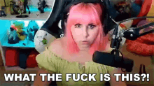 a woman with pink hair is sitting in front of a microphone and says what the fuck is this ?