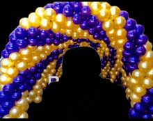 a bunch of purple and gold balloons with a letter p in the middle