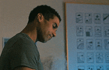 a man in a green shirt is looking at a bottle in front of a white board with icons on it