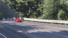 a red sports car is driving down a highway