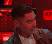 a man in a leather jacket is making a funny face