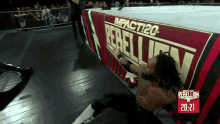 a wrestler is laying on the floor in front of a rebellion sign