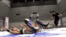 a wrestling match is underway with a sign that says stardom in the background